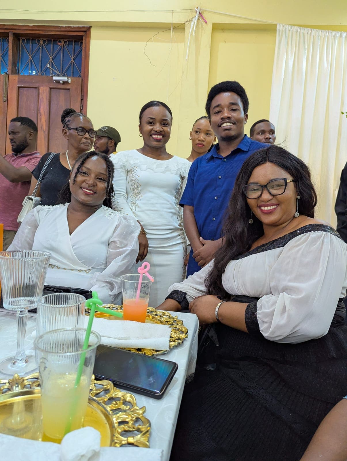 Emmanuel among friends at an indoor celebration