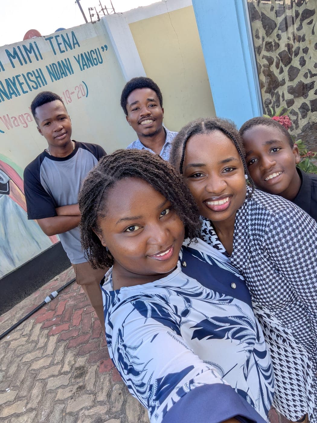 Emmanuel laughing with friends in a group selfie