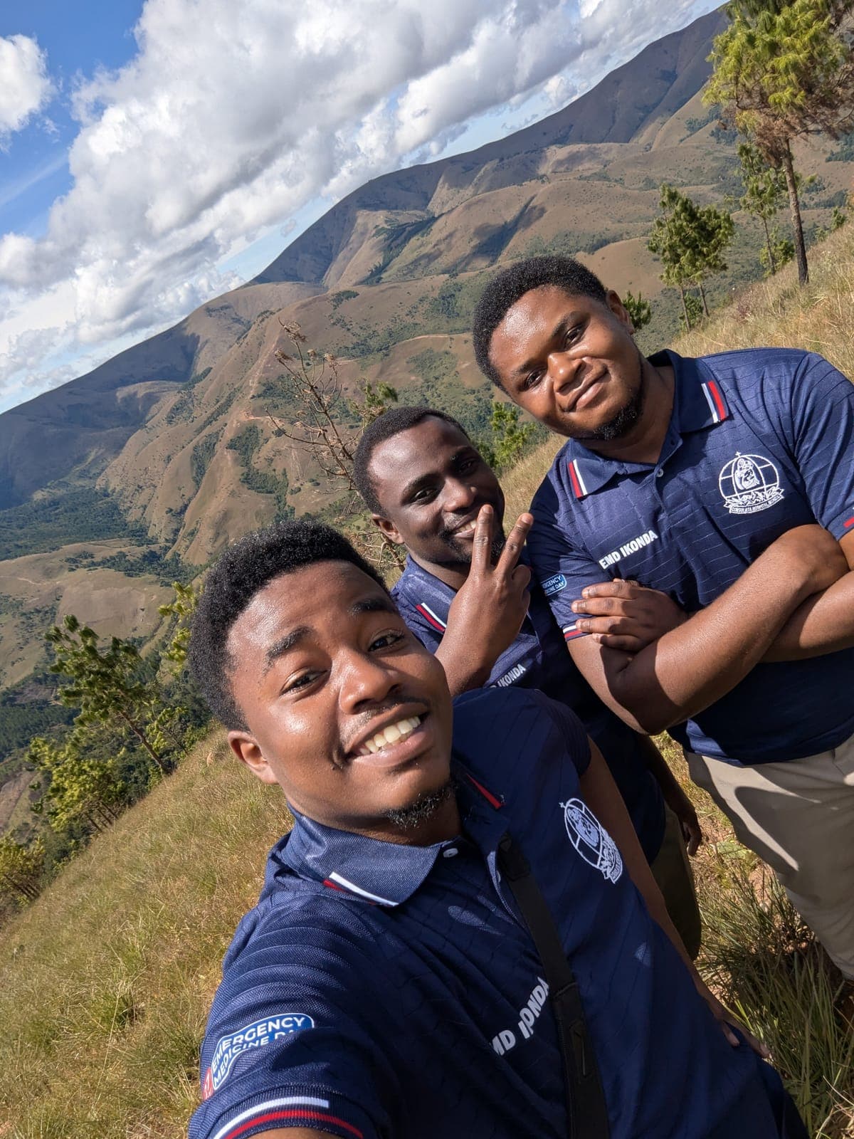 Emmanuel and a friend on a mountain ridge, valley below